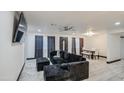 Bright living room featuring laminate floors, modern lighting, and comfortable seating area at 3915 E Hillery Dr, Phoenix, AZ 85032