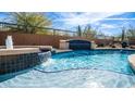 Inviting pool featuring waterfall features and blue tiled accents, creating a relaxing backyard oasis at 4109 N Twilight Cir, Mesa, AZ 85207