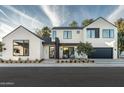 Contemporary two-story home boasts black trim windows, desert landscaping, and inviting outdoor seating area at 6338 N 10Th Dr, Phoenix, AZ 85013