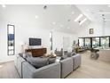 Open-concept living space with vaulted ceiling, skylights, hardwood floors, and modern gray sofa at 6338 N 10Th Dr, Phoenix, AZ 85013