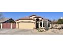 Inviting single-story home featuring desert landscaping, a spacious driveway, and a two-car garage at 6458 W Adobe Dr, Glendale, AZ 85308