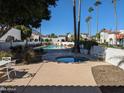 Community pool and hot tub area surrounded by palm trees and lush landscaping at 7161 E Mcdonald E Dr # 2, Paradise Valley, AZ 85253