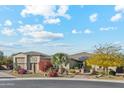 Charming home exterior with desert landscaping, three-car garage, solar panels and a circular driveway at 7662 W Artemisa Ave, Peoria, AZ 85383