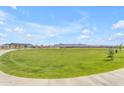 Expansive community green space featuring a shaded picnic area and picturesque mountain views at 921 W Peralta Pass, Apache Junction, AZ 85120