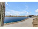 Scenic community pond with a walking path and covered dock, offering a tranquil outdoor space at 921 W Peralta Pass, Apache Junction, AZ 85120