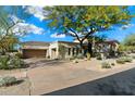 Exterior view of a home with a desert landscape, tile roof, and a multi-car garage at 9290 E Thompson Peak Pkwy # 142, Scottsdale, AZ 85255