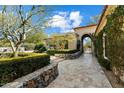 Beautiful walkway leading to an arched entryway, lush greenery, and desert landscaping at 9290 E Thompson Peak Pkwy # 142, Scottsdale, AZ 85255