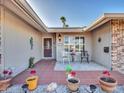 Cozy front porch with tiled floor, decorative plants, and seating area at 9313 W Arrowhead Dr, Sun City, AZ 85351