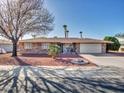 Attractive single-story home with desert landscaping, palm trees, and attached garage at 9313 W Arrowhead Dr, Sun City, AZ 85351