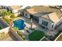 Expansive aerial view of the backyard, including a refreshing pool, patio, and well-manicured lawn at 10906 E Thornton E Ave, Mesa, AZ 85212