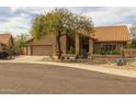 Charming home featuring a terra cotta tile roof, desert landscaping, and a two-car garage at 13220 N 99Th Pl, Scottsdale, AZ 85260