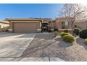 Charming single-Gathering home with desert landscaping, large driveway, and a two-car garage at 17857 W Desert View Ln, Goodyear, AZ 85338