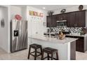 Stylish kitchen featuring stainless steel appliances, granite countertops, and a breakfast bar with barstool seating at 18644 N Desert Willow Dr, Maricopa, AZ 85138
