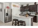 Modern kitchen featuring granite countertops, stainless steel appliances, and dark wood cabinets at 18644 N Desert Willow Dr, Maricopa, AZ 85138