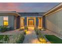 Inviting walkway to the front door featuring manicured landscaping and ambient lighting at 19912 E Natalie Way, Queen Creek, AZ 85142