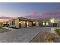 Spacious three-car garage featuring a wide driveway and modern design elements enhancing curb appeal at 19912 E Natalie Way, Queen Creek, AZ 85142