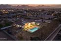 Stunning aerial view of property featuring a pool, backyard fire pit, lush landscaping and a mountain backdrop at 21442 E Excelsior Ave, Queen Creek, AZ 85142