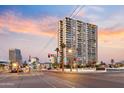 A tall apartment building is shown in a bustling downtown area with a colorful sunset sky at 2323 N Central Ave # 1902, Phoenix, AZ 85004