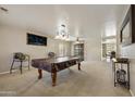 Spacious game room with a pool table, carpet flooring, and decorative lighting fixtures at 3423 E Superior Rd, San Tan Valley, AZ 85143