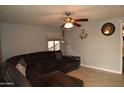 Comfortable living room features tile floors, a ceiling fan, and a large sectional sofa at 3708 W Redfield Rd, Phoenix, AZ 85053