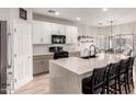 Spacious kitchen boasts a center island with seating, white cabinets, and modern appliances at 3765 E Del Rio St, Gilbert, AZ 85295