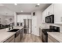 Updated kitchen features a large stainless refrigerator, a black gas range, and a breakfast bar at 3765 E Del Rio St, Gilbert, AZ 85295