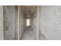 A long hallway under construction, showing drywall, and ceilings, leading to an open area at the end at 37713 N Cowboy Ln, San Tan Valley, AZ 85140