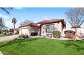 Lovely single-story home boasting a terra cotta roof, green lawn, desert landscaping and a three-car garage at 4823 S Oleander Dr, Chandler, AZ 85248