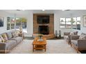 Bright living room featuring a stone fireplace, neutral furniture, and bay windows with a view at 701 W Wilshire Dr, Phoenix, AZ 85007