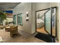 Inviting entryway featuring an open door to the living area, two chairs, and a serene outdoor view at 7721 N Via De La Montana --, Scottsdale, AZ 85258
