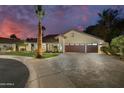 Beautiful home featuring a spacious driveway, a three-car garage, lush greenery, and vibrant palm trees at 7721 N Via De La Montana --, Scottsdale, AZ 85258