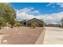 Attractive single-story home with desert landscaping, and a large driveway leading to a gated parking area at 10203 N Burris Rd, Casa Grande, AZ 85122