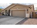 Two car garage with beige facade, and neutral trim complemented by desert landscaping at 10339 E Juanita Ave, Mesa, AZ 85209