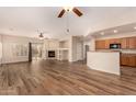 Open-concept living room featuring wood-look flooring, a fireplace, and plenty of natural light at 10339 E Juanita Ave, Mesa, AZ 85209