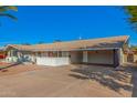 Charming single-story home features a covered carport, low white brick wall and desert landscaping at 1206 E Loyola Dr, Tempe, AZ 85282