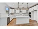 Bright kitchen featuring white cabinets, quartz countertops, stainless steel appliances, and a large island at 13386 W Eagle Feather Rd, Peoria, AZ 85383