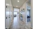 Bright hallway with tile flooring, leading to a living area and office at 139 E Desert Broom Dr, Chandler, AZ 85286