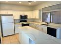 Bright kitchen featuring stainless steel appliances, countertops, and sleek white cabinetry at 14334 W Avalon Dr, Goodyear, AZ 85395