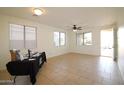 Bright living room features neutral tile flooring, multiple windows, and a ceiling fan at 14334 W Avalon Dr, Goodyear, AZ 85395