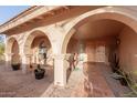 Elegant covered entrance featuring beautiful archways and a tiled path leading to double wood doors at 15843 E Mustang Dr, Fountain Hills, AZ 85268