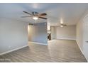 Spacious living room with ceiling fans and modern flooring flowing into the open kitchen at 1630 N 58Th Ave, Phoenix, AZ 85035