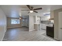 Open-concept living room and kitchen area with modern flooring, neutral walls, and ample natural light at 1630 N 58Th Ave, Phoenix, AZ 85035