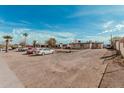 Property exterior featuring a dirt front yard, multiple parked vehicles, and single-story building at 1813 W Tamarisk St, Phoenix, AZ 85041