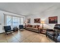 Well-lit living room with tile floors, neutral walls, and ample seating at 20006 N Concho Cir, Sun City, AZ 85373