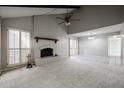 Bright living room with high ceilings, brick fireplace, ceiling fan, and large windows with wooden shutters at 2113 N Squire Ave, Tempe, AZ 85288