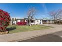 Charming single-story home featuring lush landscaping, solar panels, and a well-maintained lawn at 2302 E Sells Dr, Phoenix, AZ 85016