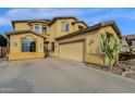 A tan home with a large driveway, two-car garage, and desert landscaping at 3238 W White Canyon Rd, San Tan Valley, AZ 85144