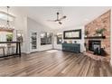 Spacious living room with a stone fireplace, ceiling fan, and plenty of natural light from the large windows at 441 S Dodge Dr, Chandler, AZ 85225