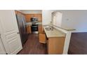 Modern kitchen featuring stainless steel appliances, wood cabinets and granite countertops at 4517 N 123Rd Dr, Avondale, AZ 85392