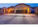 Beautiful home exterior highlighting the three car garage and desert landscaping at 4756 W Nogales Way, Eloy, AZ 85131